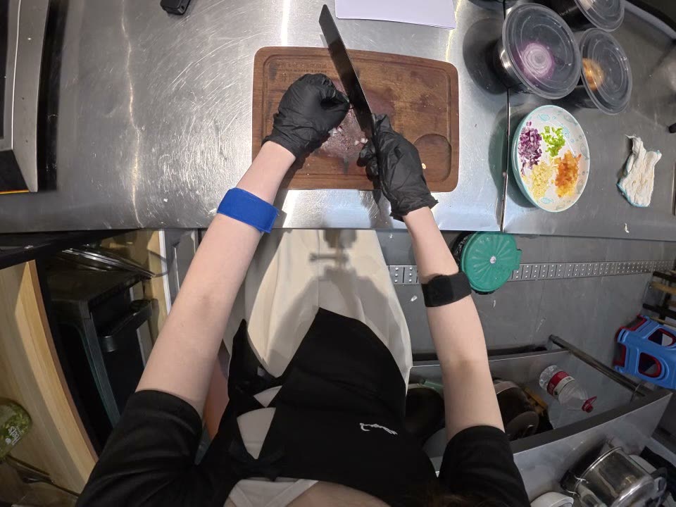 Ego camera: both hands in black gloves cutting on a board