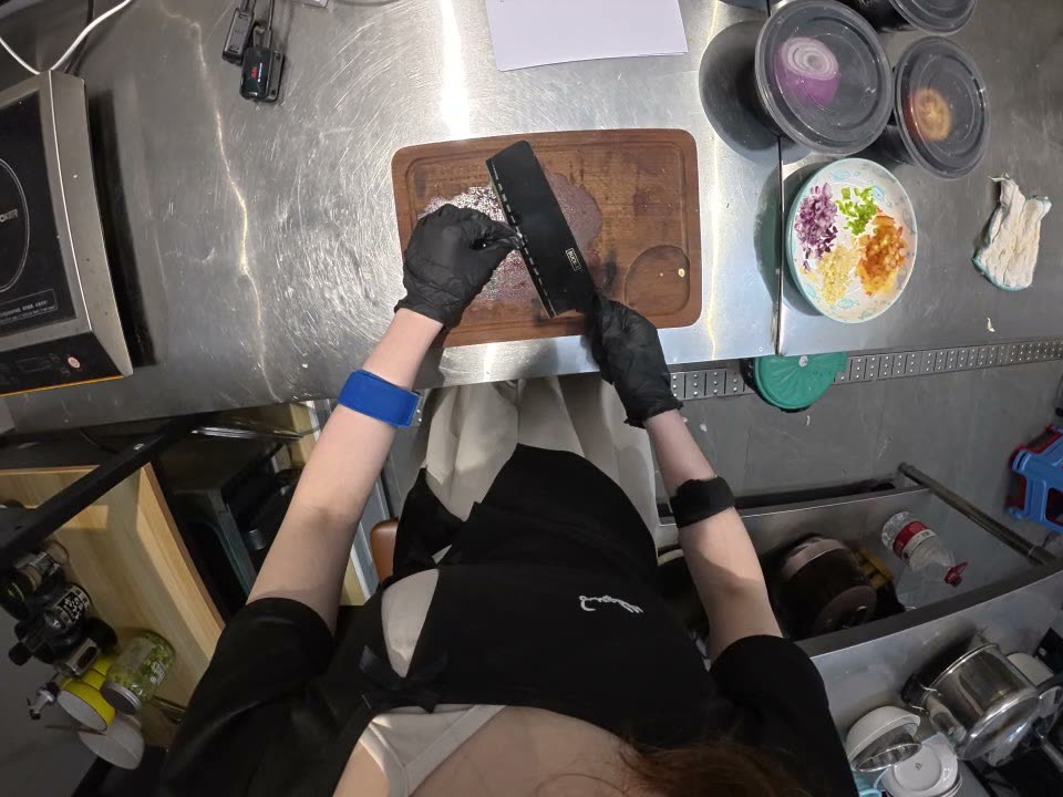 Ego camera: gloved hands with cleaver over cutting board